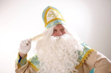 Sinterklaas portresi. Beyaz arka planda ABD. Hollandalı Noel Baba Aziz Niklas 'ın elinde yeni yıl. Beyaz bir kalem. Arzularını tatmin etmek için ne yazacağını düşünüyor.