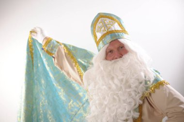 Sinterklaas portresi için reklam alanı. Beyaz arka planda ABD. Hollandalı Noel Baba Aziz Nicholas Yeni yıl pelerini Aziz Nicholas tek eliyle kaldırdı ve bir süpermen gibi sarmaladı.