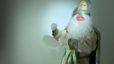 Sinterklaas portresi. Beyaz arka planda ABD. Hollandalı Noel Baba St Nicholas yeni yıl havası esiyor ve fırçayı reklam ve parti davetiyesi için boya yerine batırıyormuş gibi yapıyor.
