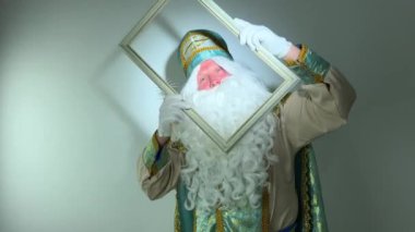 Aziz Nicholas boş bir çerçeve çiziyor güzel beyaz kalem muhteşem bir mektup büyülü bir eylem beyaz tüylü bir sakalı var altın rengi Noel Baba 'lı bir takım elbise reklamı ve parti davetiyesi yeri