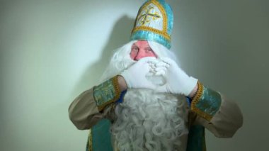Noel Baba turkuaz takım elbisesinin kurucusu Aziz Nicholas 'ın farklı pozitif duyguları vardı. Geleneksel bir dini şapkayla, tıpkı bir papazın cübbesi ve kemeri olması gibi.