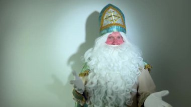 Noel Baba turkuaz takım elbisesinin kurucusu Aziz Nicholas 'ın farklı pozitif duyguları vardı. Geleneksel bir dini şapkayla, tıpkı bir papazın cübbesi ve kemeri olması gibi.