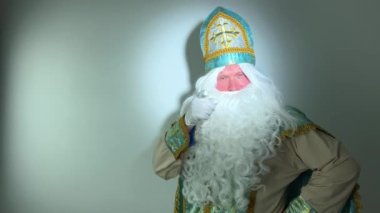 Noel Baba turkuaz takım elbisesinin kurucusu Aziz Nicholas 'ın farklı pozitif duyguları vardı. Geleneksel bir dini şapkayla, tıpkı bir papazın cübbesi ve kemeri olması gibi.