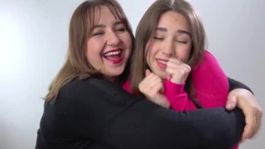 Anne ve kızının güzel bir ailesi var, evde sarılıp öpüşüyorlar. Büyük anne ve yetişkin kızı kucaklaşıyorlar, kameraya bakıp gülümsüyorlar anne ve kız meme için kayıt yaptırıyorlar.