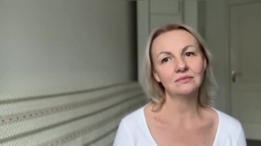 Düşünceli kadın, boş fotokopi alanına karşı günlük beyaz tulumlar içinde dalgın dalgın bakıyor. Çünkü reklam içeriğiniz gelecekteki yetişkin sarışını düşünüyor.