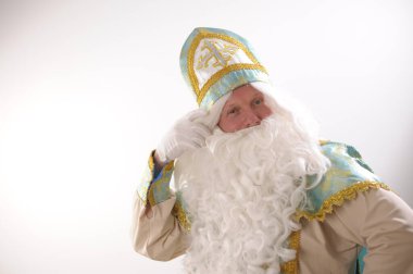 Noel Baba turkuaz takım elbisesinin kurucusu Aziz Nicholas 'ın farklı pozitif duyguları vardı. Geleneksel bir dini şapkayla, tıpkı bir papazın cübbesi ve kemeri olması gibi.