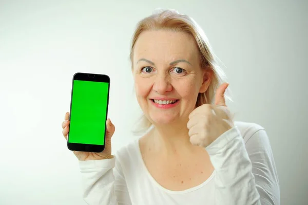 プロダクト広告の手を示す女性ねえ見てください 笑顔かわいい女性モデル指して指左で空のスペースと招待にそれをチェックアウト上の白い背景緑の画面Chromakey電話 — ストック写真