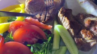 Bıçak ve çatalla sulu ızgara fileto dilimleme bıçak ve çatalla kesme lezzetli ızgara wagyu bifteği rosto tabakta taze sebze ve kızarmış et bir parça biftek buharı kesilir.