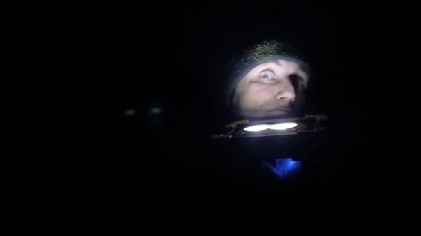 Человек Подсветкой Фонарик Глядя Сторону Темноте Лицо Фонариком Снизу Страшный — стоковое видео