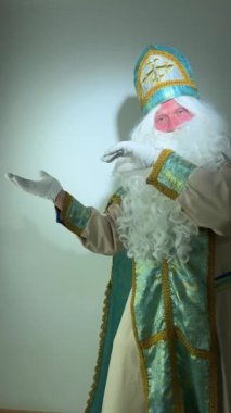 Yaşlı, komik, sakallı Noel Baba Aziz Nicholas hediyesini tutuyor, konuşuyor, hediye kutusunu Mutlu Noeller kutluyor, depo atölyesinde duruyor, xmas satış konsepti