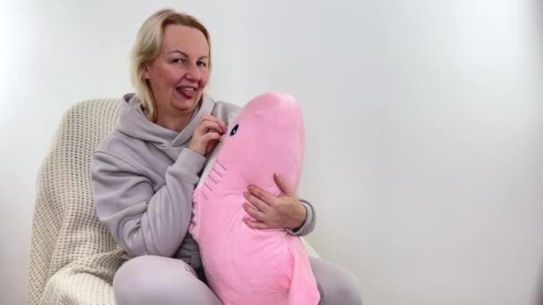 Vrouw Een Warme Sportkleding Houdt Een Roze Haai Zacht Speelgoed — Stockvideo