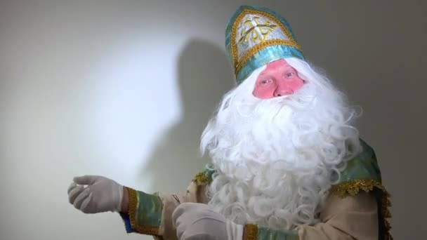 面白い古いひげを生やしたサンタクロース 聖ニコラスはメリークリスマスにカメラの挨拶に話してハッピーニューイヤー 倉庫のワークショップに立って ウェブカメラによるビデオ通話オンライン仮想チャットの概念4K — ストック動画