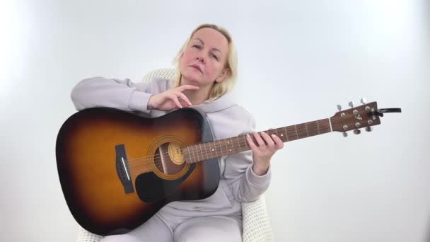 Mulher Loira Tocando Guitarra Clássica Relaxado Com Expressão Séria Rosto — Vídeo de Stock