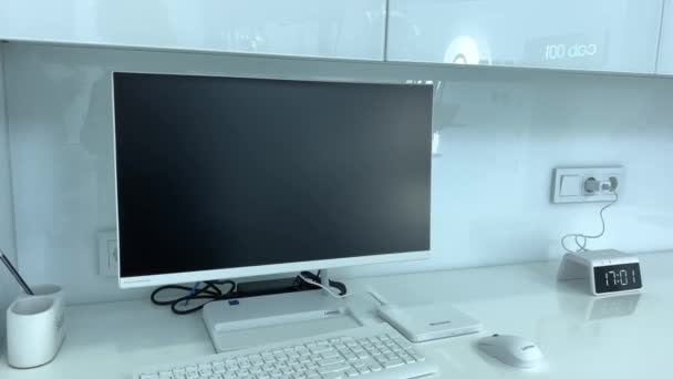 テーブルの上に空白の画面を持つノートパソコンライトシンプルなワークスペースのモックアップモニターは時計の横のテーブルの上にあります マウスとキーボード ショップや病院 — ストック動画
