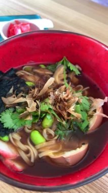 Japon erişte çorbası, tavuk soğanı ve koyu ahşap arka planda Miso Ramen Asya eriştesi yumurta, domuz eti ve lahana ile Japon mutfağı sarımsaklı kişniş zencefil yanında da lahana.