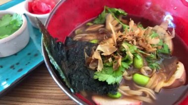 Japon erişte çorbası, tavuk soğanı ve koyu ahşap arka planda Miso Ramen Asya eriştesi yumurta, domuz eti ve lahana ile Japon mutfağı sarımsaklı kişniş zencefil yanında da lahana.