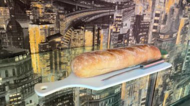 Beyaz bir tahtanın üzerinde taze pişmiş ciabatta ekmeği. Beyaz bir porselen tahtanın üzerindeki güzel bir mektup. Cam bir masanın üzerinde, arka plandaki karanlık bir duvar kağıdına karşı.