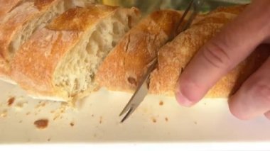 Beyaz bir tahtanın üzerinde taze pişmiş ciabatta ekmeği. Beyaz bir porselen tahtanın üzerindeki güzel bir mektup. Cam bir masanın üzerinde, arka plandaki karanlık bir duvar kağıdına karşı.