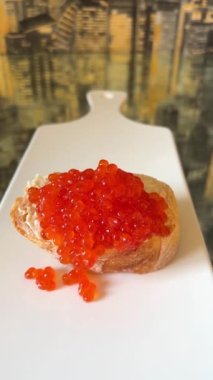 Bir parça tereyağlı ekmeğe bir sürü kırmızı havyar konur. Bir tabak kaşığa düşmez. Tahılları çok düzeltirim, her biri iştah açıcı büyük sandviçtir.