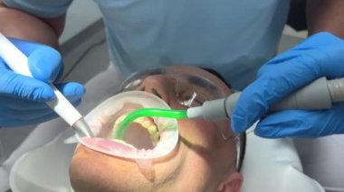 Diş hekiminde dişçi hasta asistanı. Hastanede bir erkek hastayı tedavi eden diş hekimleri. Kıyamet Günü Diş Temizleme Doktoru ve Mavi Temiz Steril Kliniği 'nde asistan.