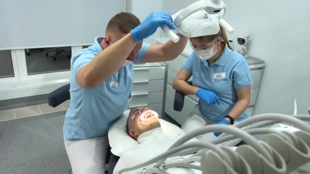 在牙医治疗期间的牙医病人助理 在医院治疗男病人的牙科医生清洁医生及蓝色清洁消毒诊所的助理 — 图库视频影像