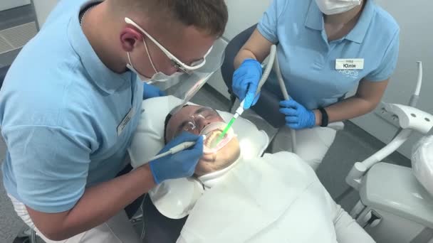 Dokter Dalam Sarung Tangan Biru Menerapkan Salep Untuk Gigi Pasien — Stok Video