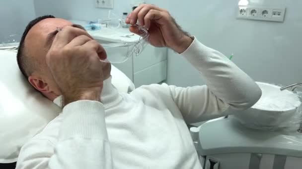 Yakışıklı Yetişkin Bir Adam Dişçi Koltuğunda Şeffaf Gözlük Takar Böylece — Stok video