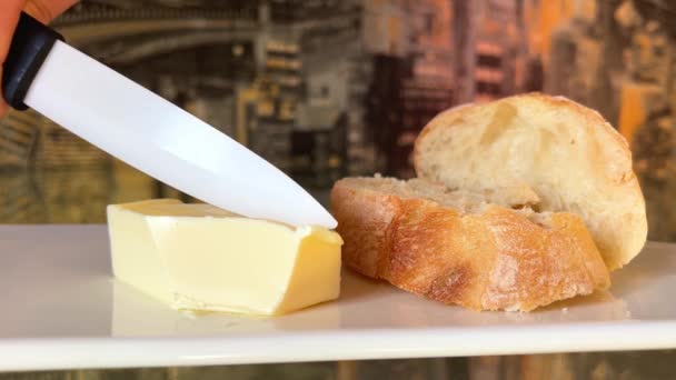 Messer Einer Frauenhand Schneidet Ein Stück Butter Auf Einem Weißen — Stockvideo