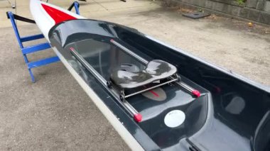 Kano teknesi özel olarak ayakta duruyor. Kamera kamerayı çekerken yavaşça süzülüyor. Bir kişi için beyaz, su sporları okulunun yeni kano talimatı hikayesine ekleniyor.