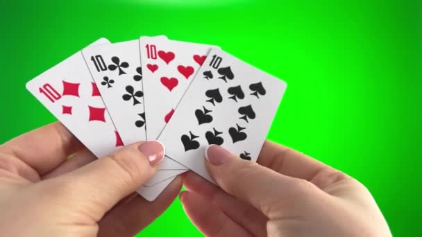 緑の背景のクローズアップに4ダースを保持手フランスマニキュアとカードの女性の手で10 女性はカードを並べ替え 折り目を調べ 同じスーツの左のファン4枚のカードのように広がり — ストック動画