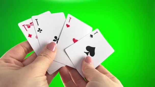 フランスのマニキュアで緑の背景クローズアップ女性の手に4つのエースを保持手 女性はカードを並べ替え折り目を調べ同じスートのファン4枚のカードのように広がり — ストック動画