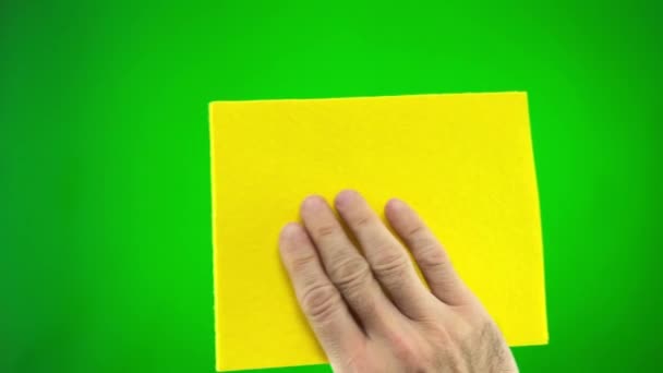 男人毛茸茸的手拿着黄色的餐巾他擦拭屏幕绿色的铬色背景广告餐巾被擦拭它是由男人的概念艾斯卡德清洁了不必要的信息清洁 — 图库视频影像