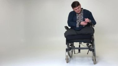 Erişkin erkek Ukraynalı Kozak, nakışlı gömlekle gömleğini düzeltiyor. Gömleğinin koluna düğmeler takıyor. Mavi vyshyvanka, koluna mavi işlemeli yüzükler takıyor.