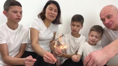 Partide maytapla mutlu bir aile kutlaması. Arkadaşlık, Havva ve tatil konsepti hakkında sohbet eden bir grup insan. 5 kişi, 3 oğul, anne ve baba.