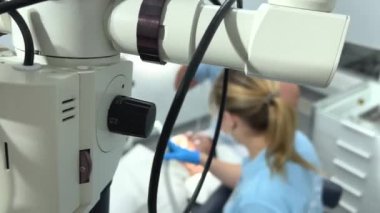 dentistry trainees learning to treat teeth microscope 2 young people who put a lip cheek retractor on patient while they themselves are busy adjusting glasses talking initial training unskilled