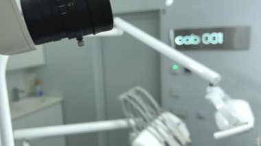 microscope dental clinic doctors working treating teeth patient latest technology blue sterile gloves health treatment concept dental prosthetics remove stone put filling in mouth lip cheek retractor