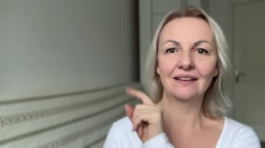 İlanınızın el ele tutuşup el ele dans edebileceği üç yeri işaret edin. Gülümseyen kadın model boş alanı işaret ederek reklam gösteriyor.