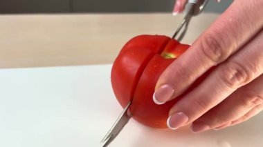 womans hands using kitchen knife cutting fresh tomato on wooden cutting board. Healthy eating. Sliced tomato. High quality 4k footage