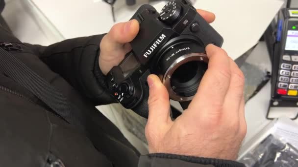 Fujifilm H2S镜头适配器的人打开了Fujifilm相机适配器的镜头从尼康相机手中 Holds Close Next Terminal Store Delivery Point Ukraine — 图库视频影像