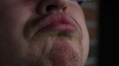 middle-aged adult man with red beard lets out air with his mouth he claps lips cheeks puff out funny slow motion video close-up only mouth then camera drives by filming wearing glasses funny video