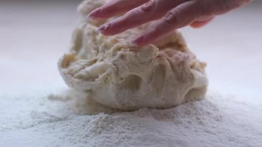 kneading the dough slow motion falling fly Woman making batter at light table closeup dough falls into flour on the table, the flour flies in different directions homemade baking cooking bakery bread