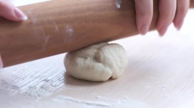 Womens hands rocking chair rolls out the dough but it sticks and does not want to distract the unsuccessful rolling of a bad dough home baking for the first time we teach it is easy to learn