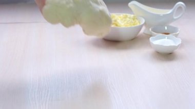 woman takes rolling pin from table and puts dough yeast approached fermentation she swings it on light table sprinkled with flour against the background ingredients sprinkles dough with flour