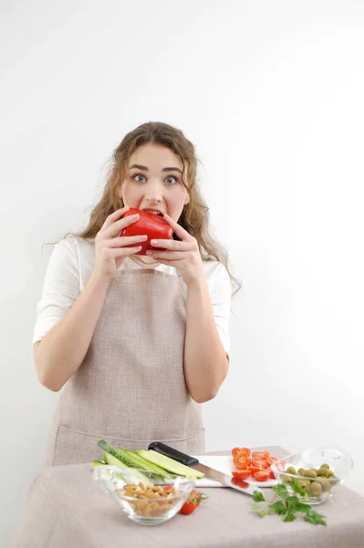 biting sweet pepper woman happy smile cute woman cooking at home happy young woman biting red pepper teenager beautiful girl close-up healthy food diet proper food
