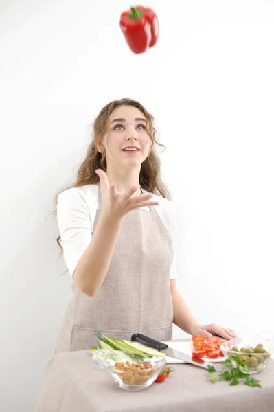 young beautiful girl woman throws bell pepper up She looks at him smiling trying to catch cooking salad vegetarian food weight loss Beauty and health the power of life fun fresh vegetables