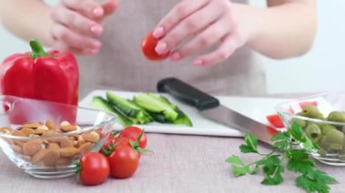 Smiling young woman serving fresh salad on plate. Happy smiling cute woman cooking fresh healthy vegan salad at home with many vegetables in kitchen and trying new recipe High quality photo
