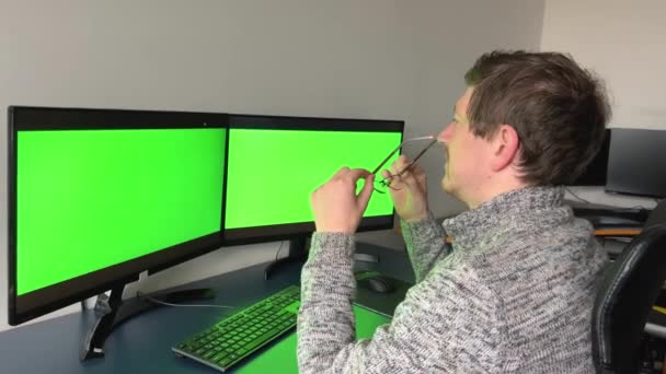 Close Green Screens Two Monitors Man Dark Sits Back Camera — Video Stock