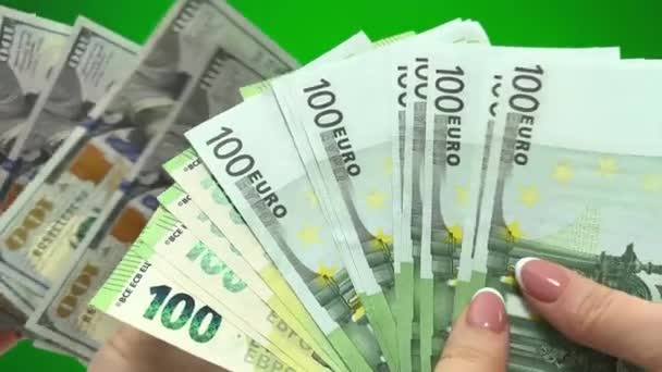 為替オフィスユーロを前景女性のドルに変更すると 100の紙幣100ユーロ紙幣が背景男性の手にそれらを積み重ねることを考えています100ドル紙幣クロマキーグリーン — ストック動画