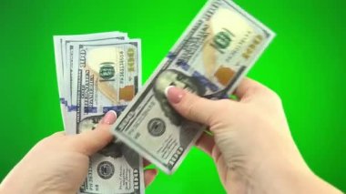  stack of 100 dollar bills on green chromakey background female hands put dollars together counting each bill and stretch forward where you can put your ad money