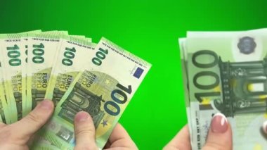 exchanging old 100 euro bills of banknotes for new mens hands counting old banknotes of women changing to new ones Green background chroma key business purchase buying house apartment trip travel